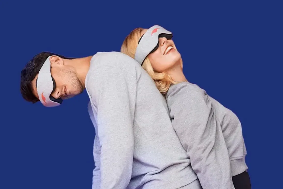 Couple dos à dos portant des masques de sommeil Manta Sleep sur fond bleu